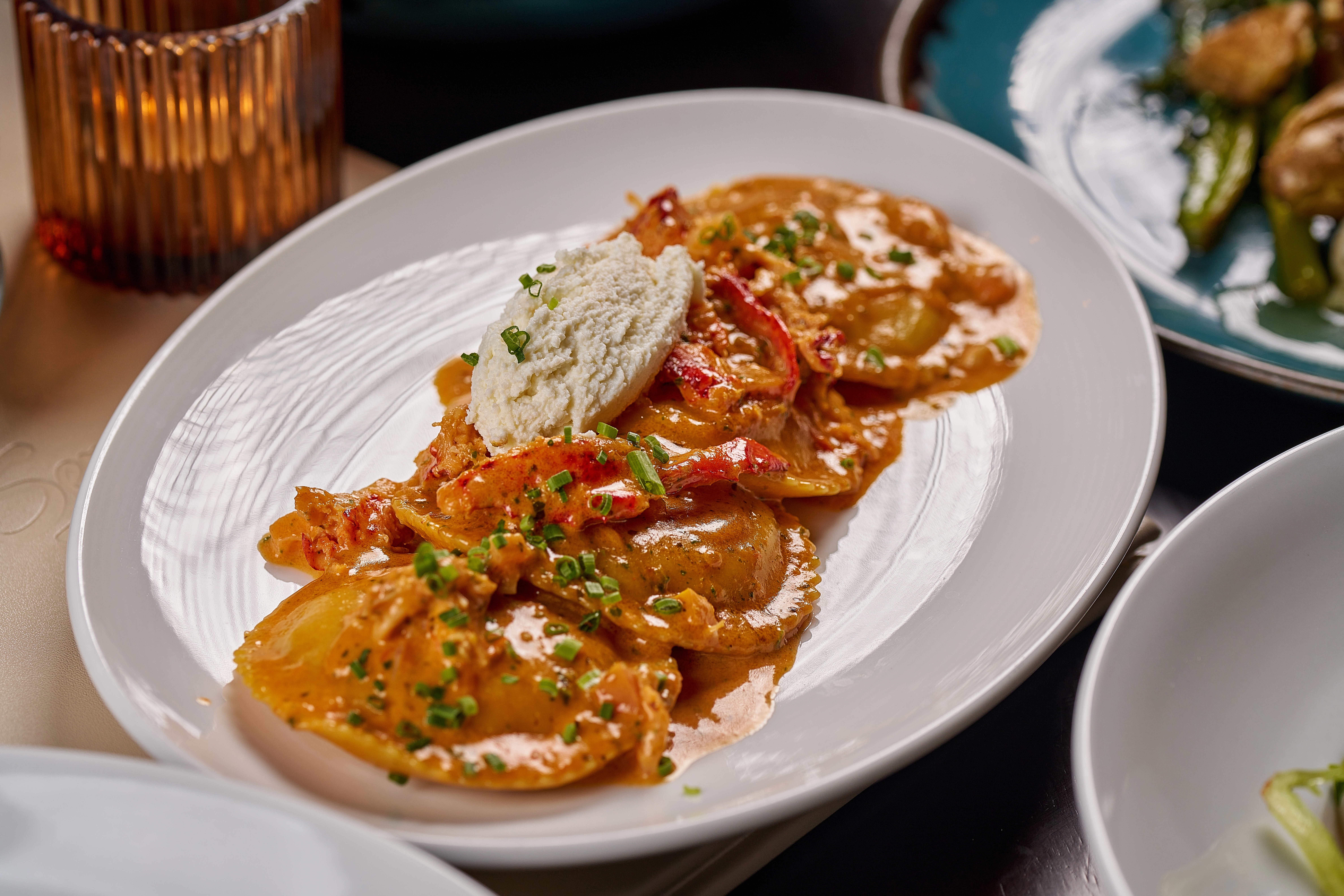 Plate of shrimp ravioli with creamy sauce and cheese topping
