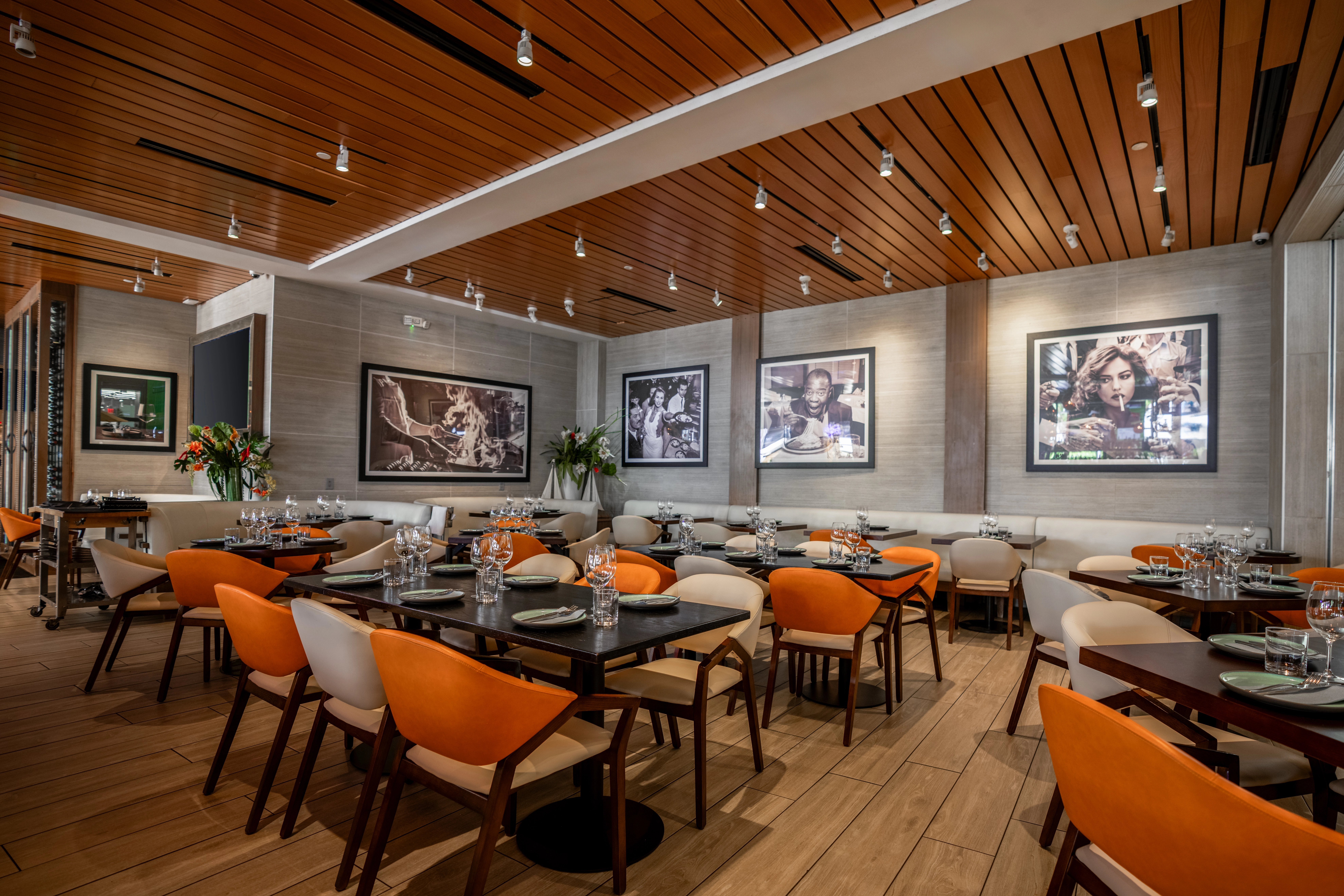 Elegant restaurant dining room with orange chairs and modern art in Aventura Mall