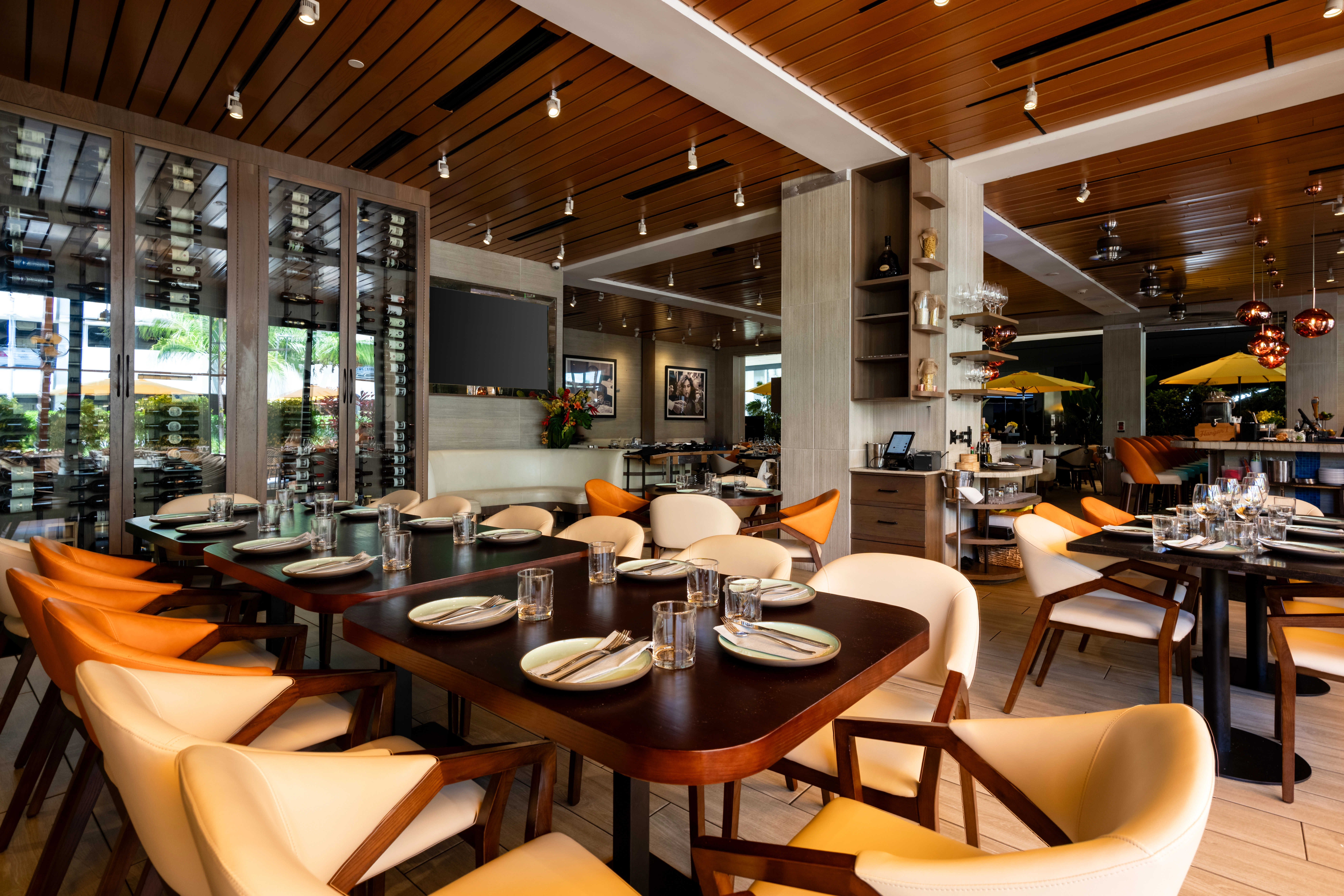 Aventura Mall restaurant dining area with wooden tables, cushioned chairs, and wine racks